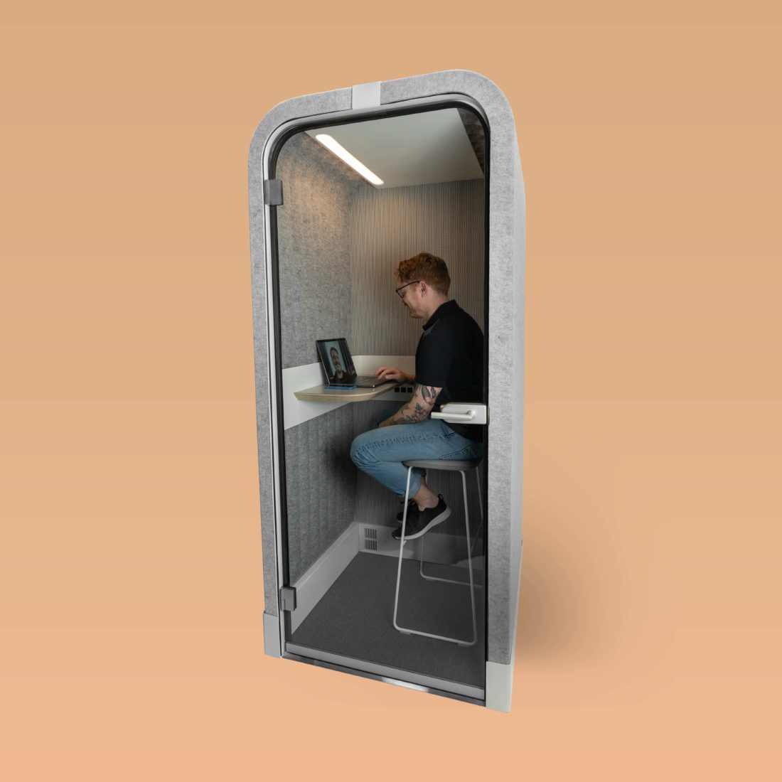 Man sits inside a Loop Phone Booths Flex