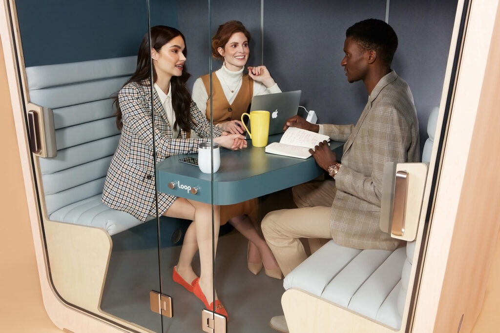 People having a meeting inside a loop cube privacy pod