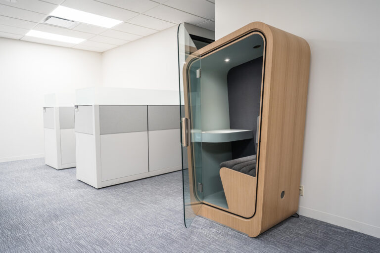 a loop solo office pod with a wood exterior sits in a typical looking office