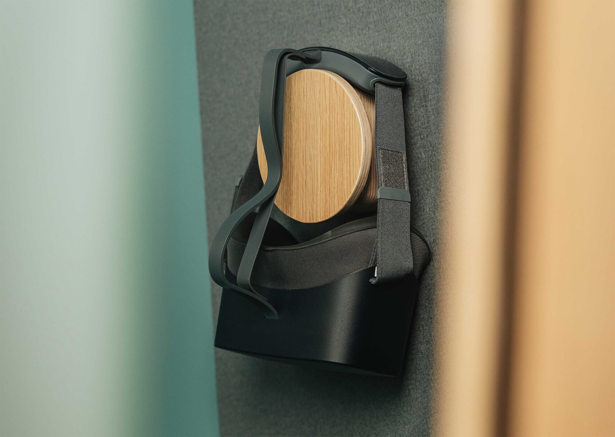 black virtual reality goggles sit on a custom hanger inside a loop solo phone booth