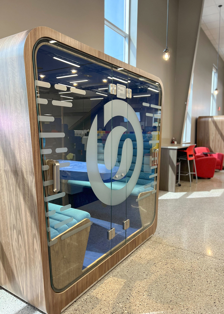 Loop Cube meeting pod with vinyl frosted graphics on the front glass in a modern open office